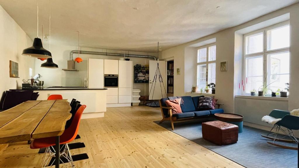 a kitchen and living room with a wooden table and chairs at ApartmentInCopenhagen Apartment 1538 in Copenhagen