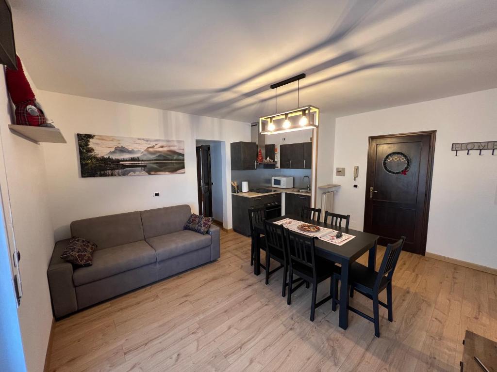 sala de estar con sofá y mesa de comedor en Residence Valtellina - Salita Baradello en Aprica