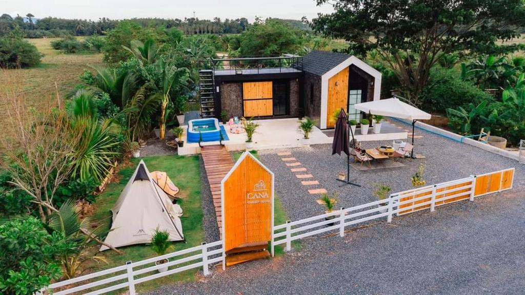 a tiny house with a tent and a table at Cana​ Garden​ House​ โฮมสเตย์​ in Ban Khok