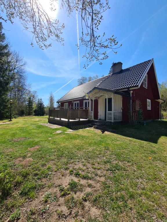 ein rotes und weißes Haus mit einem Hof in der Unterkunft Tosthult holiday 3 in Lönsboda