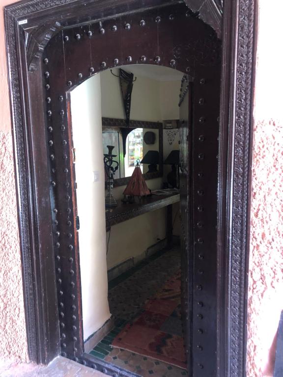 a large wooden mirror with a wooden frame at riad msholidays - privatisé jusqu'à 6 personnes - bassin in Marrakesh
