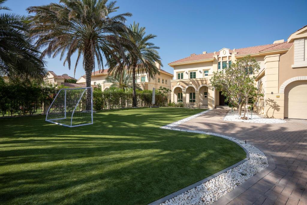 a yard with a swing in the grass at Jumeirah Islands Private Pool Villa in Dubai