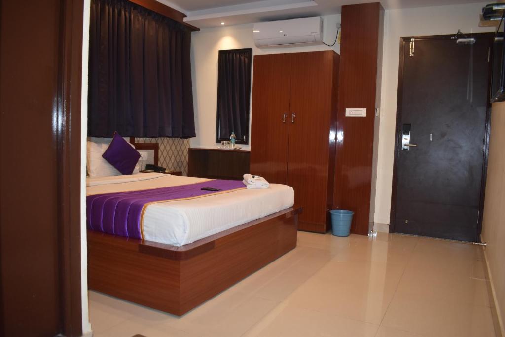 a bedroom with a bed in a room at Hotel UR Comforts Jayanagar in Bangalore