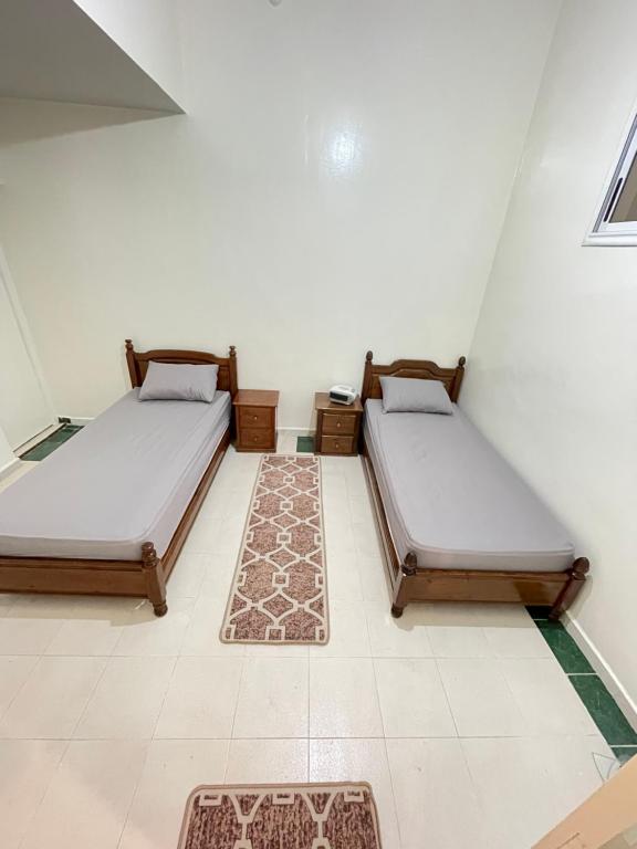 a room with two beds and a rug at Cente ville House in Agadir