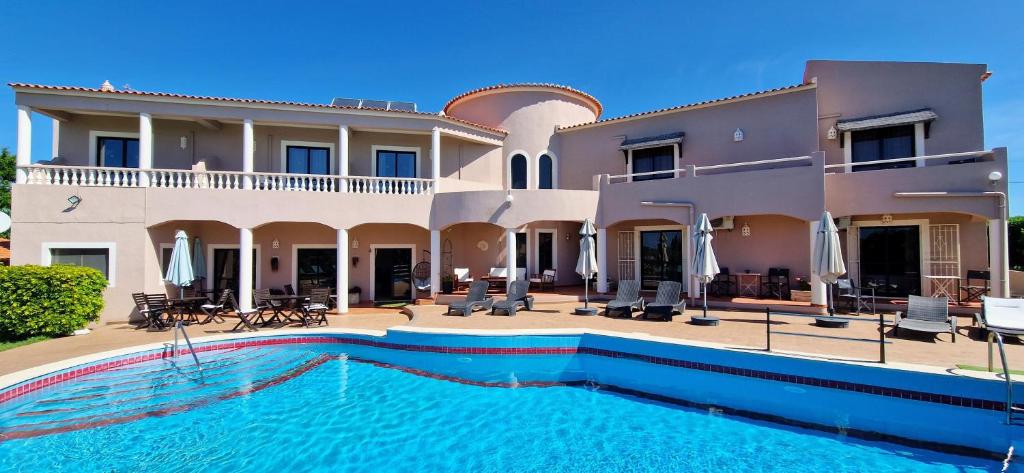 une maison avec une piscine en face de celle-ci dans l'établissement Casa Rosa Montes, à Luz