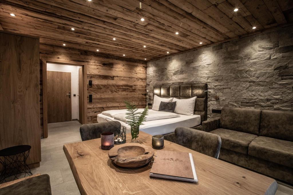 a bedroom with a bed and a table and a couch at Apartment Alpinflair 1 in Kaprun