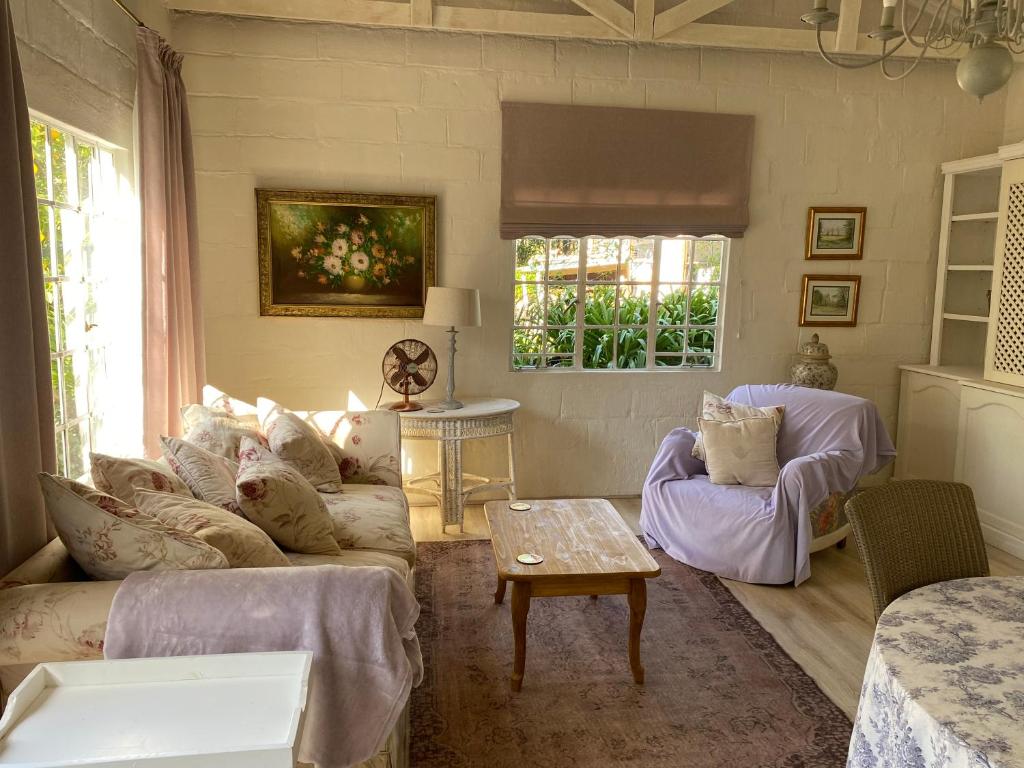 a living room with a couch and a table at Dainty Bess cottage in Middelburg