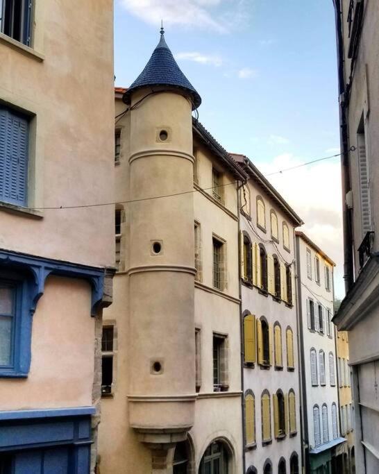 a building with a tower on the side of it at Bel appartement, 2 chambres, centre ville in Thiers