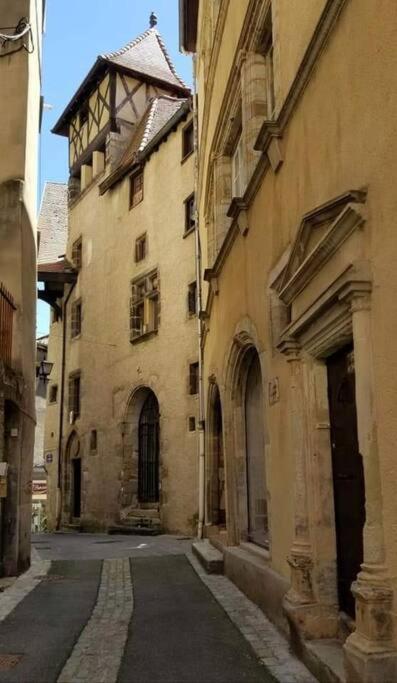 an alley in an old building with a tower at Bel appartement, 2 chambres, centre ville in Thiers