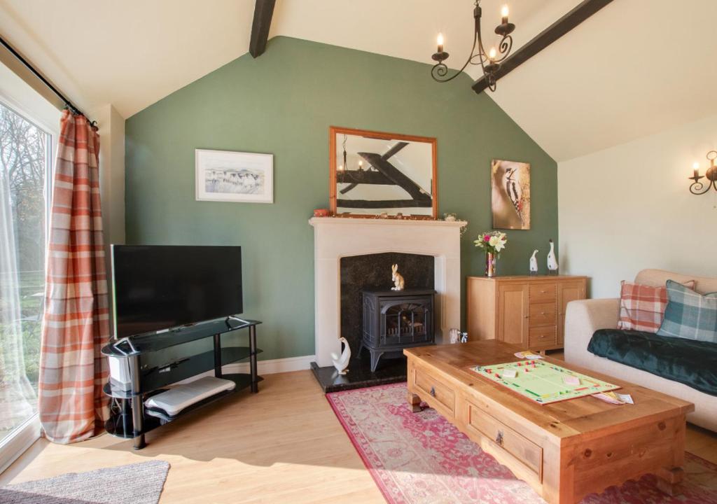 a living room with a couch and a fireplace at Woodpecker View in Kirby Misperton