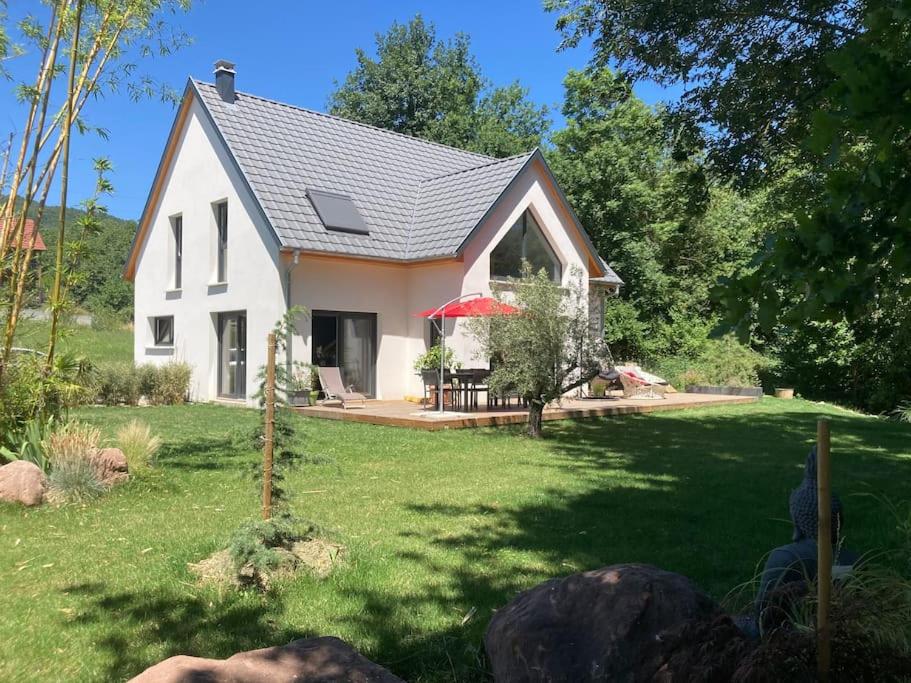 uma pequena casa branca com um quintal com um relvado sidx sidx em Magnifique maison cadre bucolique em Walbach