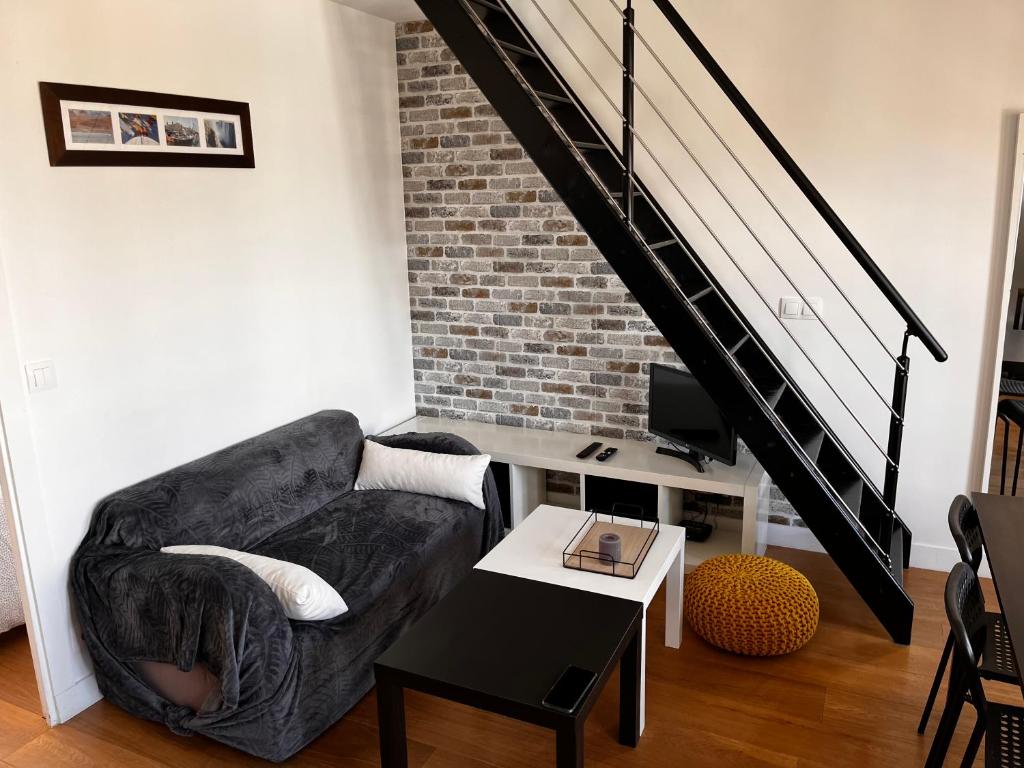 uma sala de estar com um sofá e uma mesa em Appartement Saint Germain en Laye em Saint-Germain-en-Laye