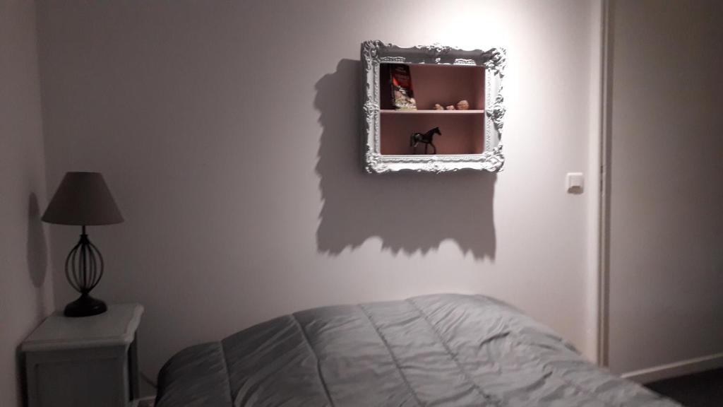 une chambre avec un lit et un miroir au mur dans l'établissement gite typique ardechois sous le figuier, à Vals-les-Bains