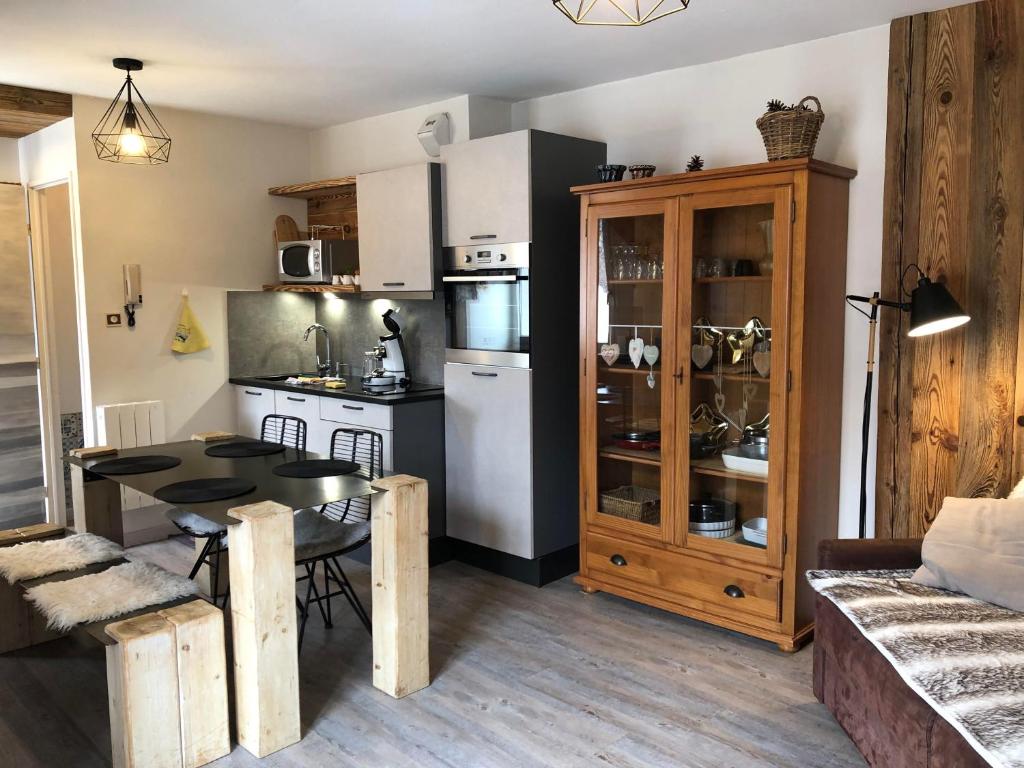 ein Wohnzimmer mit einem Tisch und einer Küche in der Unterkunft Le Carrousel 4-6p Plein centre in Gérardmer