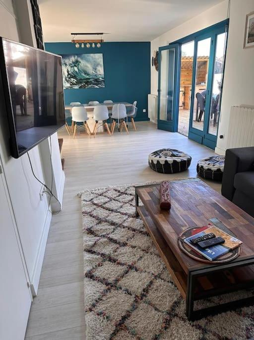 a living room with a tv and a table at Maison de vacances Bisca in Biscarrosse