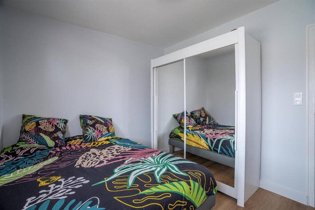 a bedroom with a bed and a mirror at Maison de vacances Bisca in Biscarrosse