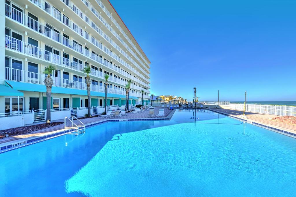une grande piscine devant un immeuble dans l'établissement Harbour Beach Resort, à Daytona Beach