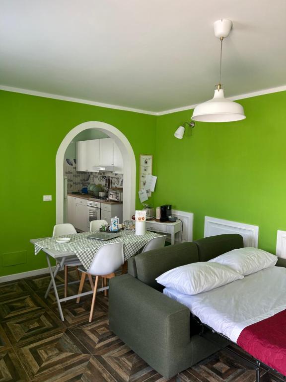 uma sala de estar verde com um sofá e uma mesa em Casa Vacanza e B&B em Amica