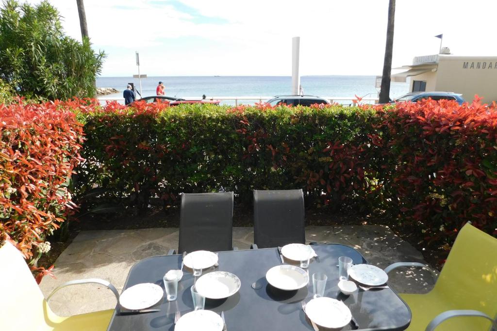 een blauwe tafel en stoelen met de oceaan op de achtergrond bij Charming T3 "Plein Sud" feet in the water air-conditioned in Juan-les-Pins