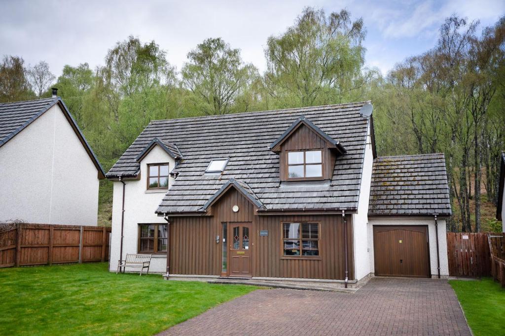 a house with a gambrel roof and a garage at Bracken House in Aviemore