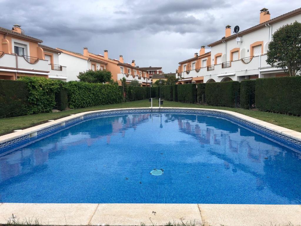 a large blue swimming pool in front of some buildings at Casa Sobrestany L’Estartit in L'Estartit
