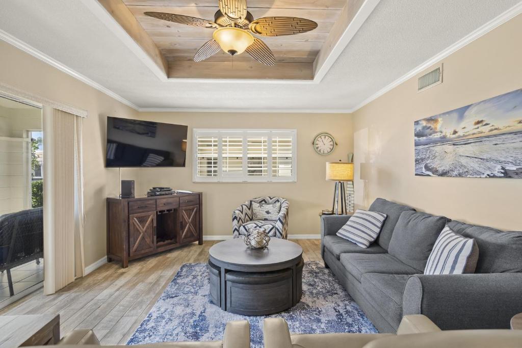 a living room with a couch and a ceiling fan at Island House Beach Resort 25 in Point O'Rocks