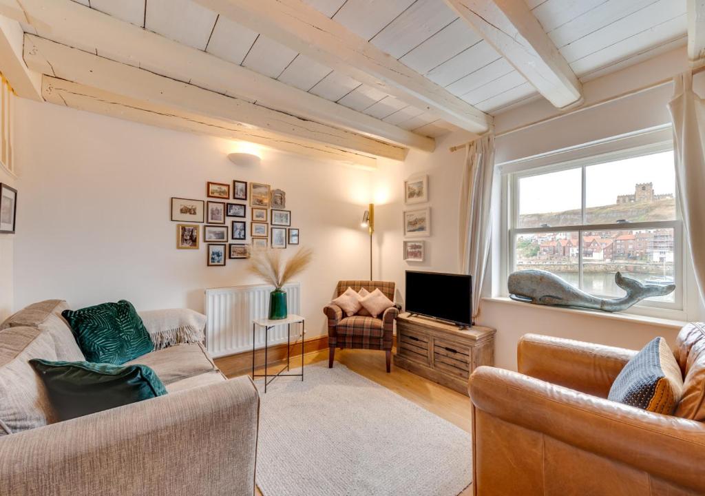 ein Wohnzimmer mit 2 Sofas und einem TV in der Unterkunft Alice Cottage in Whitby