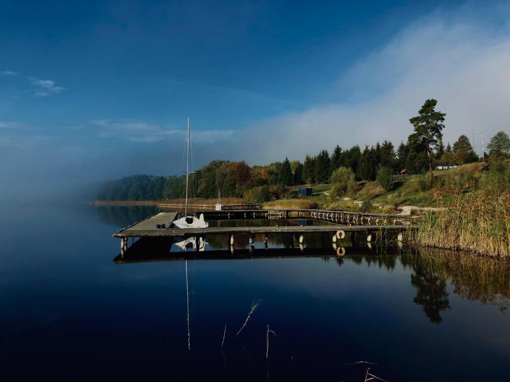 Ein Boot liegt an einem Dock auf einem See. in der Unterkunft Piękny Dom na wodzie!!! Mazury szlak WJM in Ryn