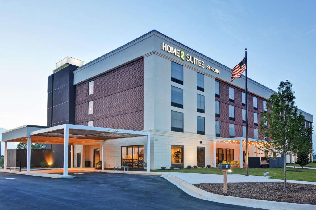 a building with an american flag in front of it at Home2 Suites By Hilton Madison Huntsville Airport in Madison