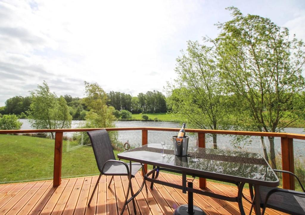 - une table et des chaises sur une terrasse avec vue sur le lac dans l'établissement Waters Edge, à Routh