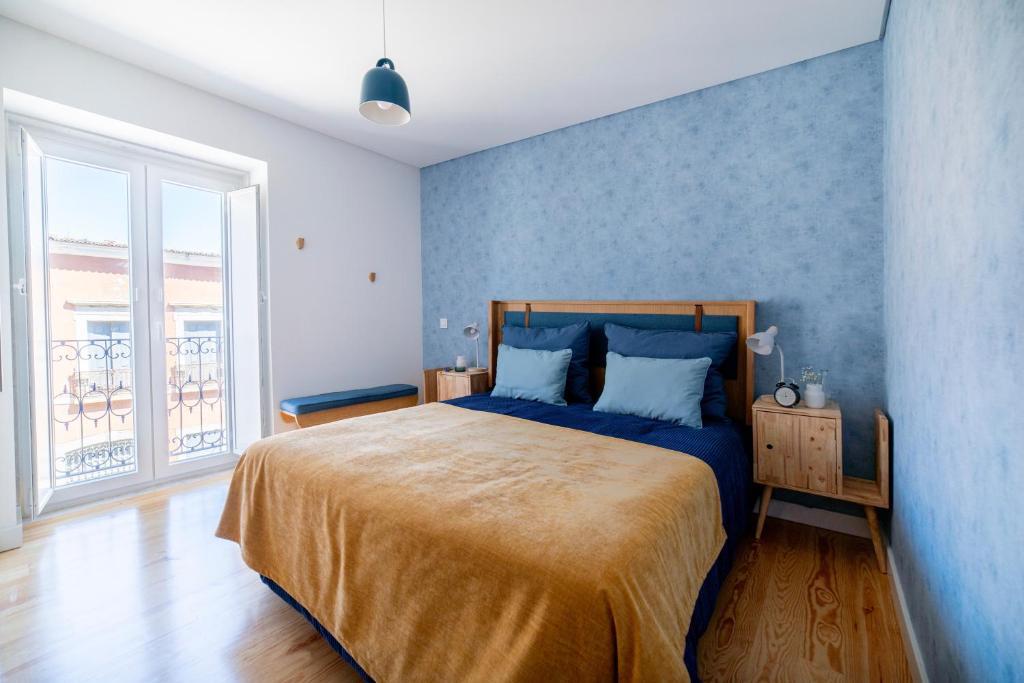 Blue by the River 3 - elegant two-bedroom in Santos في لشبونة: غرفة نوم بسرير مع جدار ازرق