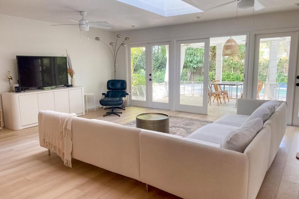 a living room with a white couch and a tv at Modern Oasis in Sarasota