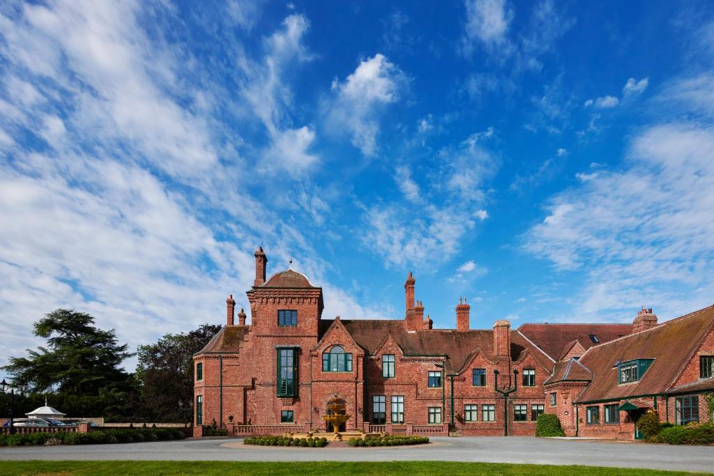 a large brick building with a blue sky in the background at Aldwark Manor Estate in Aldwark