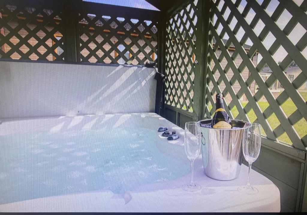 eine Badewanne mit zwei Gläsern und eine Flasche Wein in der Unterkunft Walkers Retreat in Routh