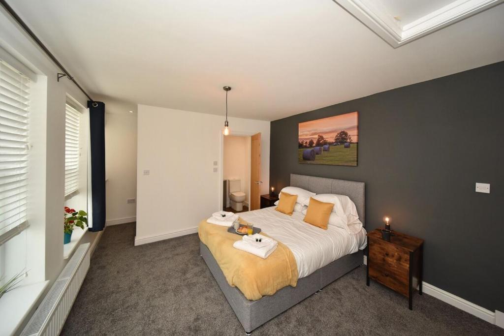 a bedroom with a bed and a table in it at Pinfold Suite - Chester Road Apartments By in Macclesfield
