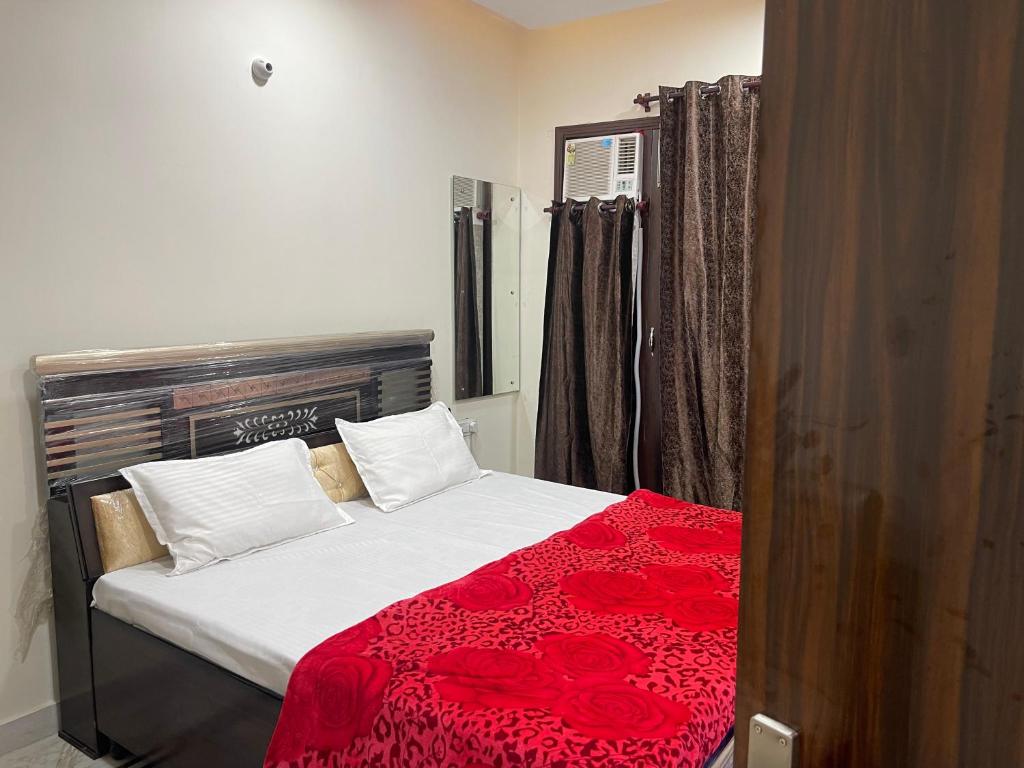 1 dormitorio con 1 cama con manta roja en Homestay Comforts 500m from Amritsar Airport en Amritsar