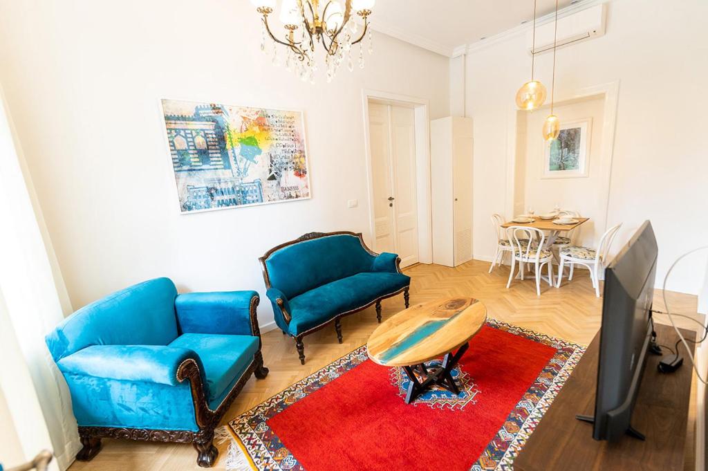 ein Wohnzimmer mit 2 blauen Stühlen und einem Tisch in der Unterkunft Luxury Suite / Josip Vancaš in Sarajevo