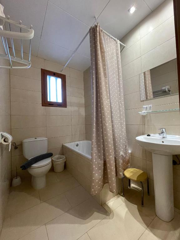 Un baño con bañera, inodoro y lavabo. en P&R hostals Codolar, en Tossa de Mar