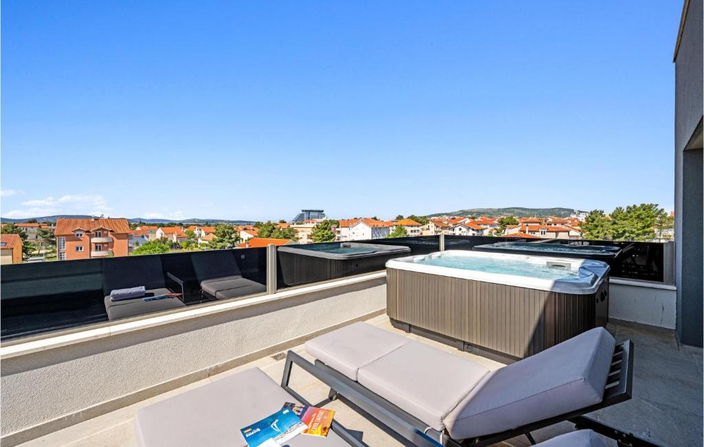 a balcony with a hot tub and patio furniture at 3 Bedroom Amazing Apartment In Vodice in Vodice