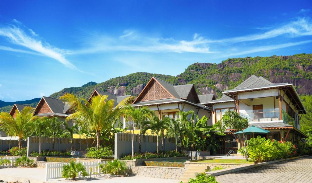 una fila di case di fronte a una montagna di JA Enchanted Waterfront Seychelles a Mahe