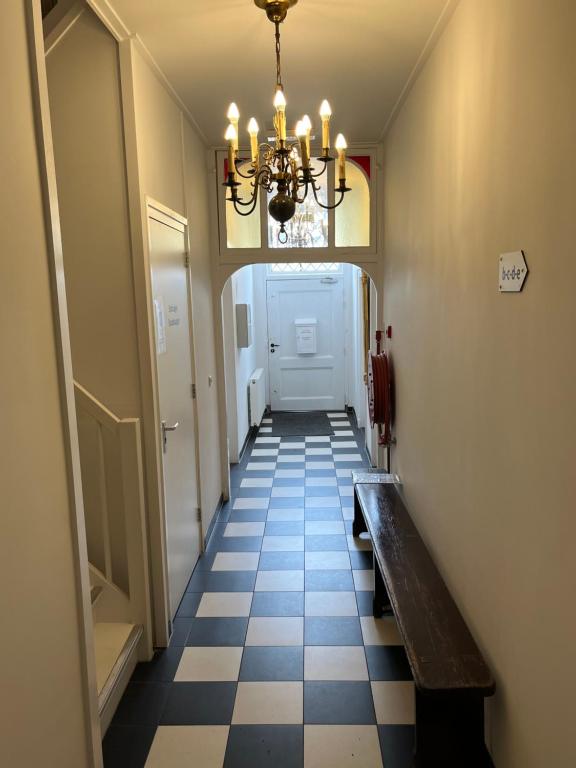 a hallway with a bench and a chandelier at Residence het Centrum in Oostkapelle