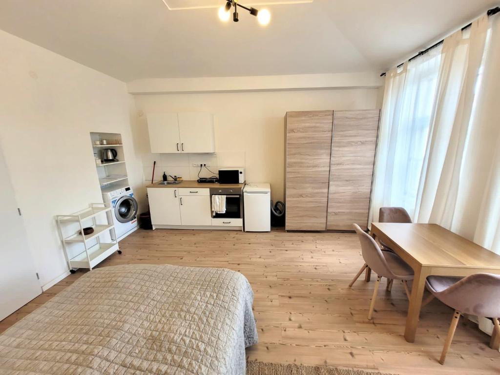 a room with a bed and a table and a kitchen at Cozy apartment close to Palmovka in Prague