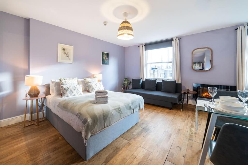 um quarto com uma cama e um sofá num quarto em [Bayswater-Hyde park] London Studio Apartment em Londres
