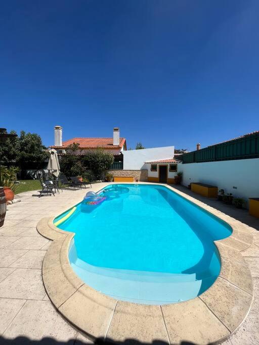a large blue swimming pool in a courtyard at Cafofos da Zeta, Cozy Pool House in Quinta do Conde