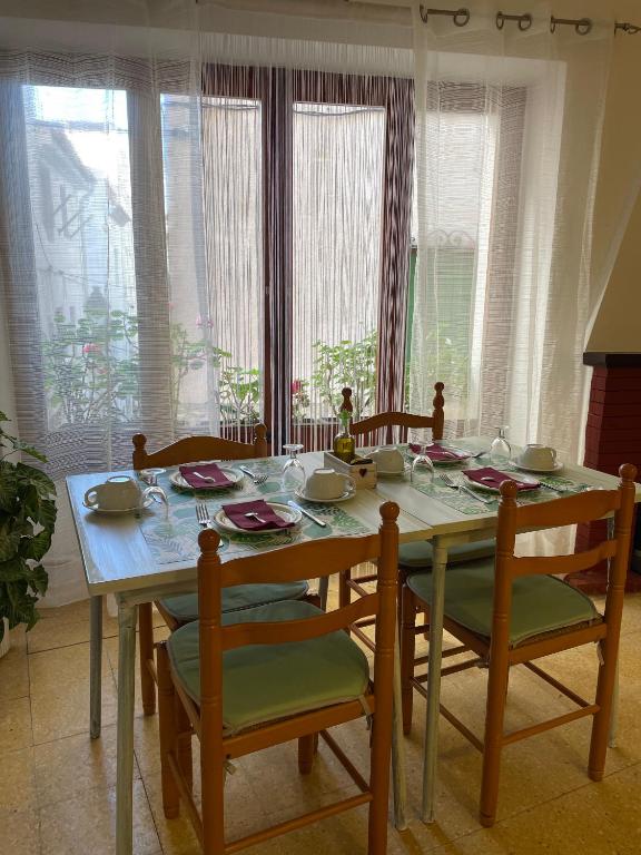 una mesa de comedor con sillas y una mesa con platos. en P&R hostals Codolar, en Tossa de Mar