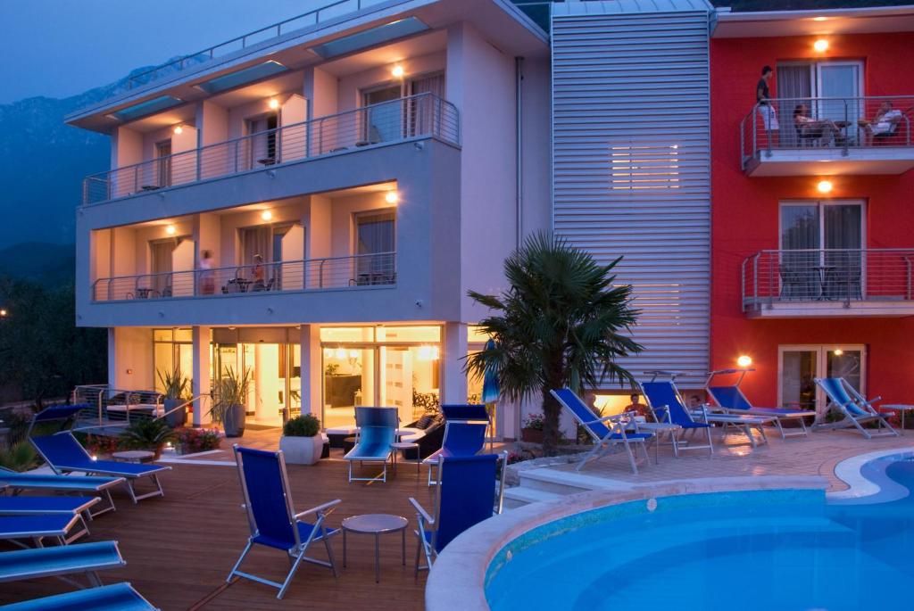 a hotel with chairs and a swimming pool in front of it at Hotel Campagnola in Malcesine