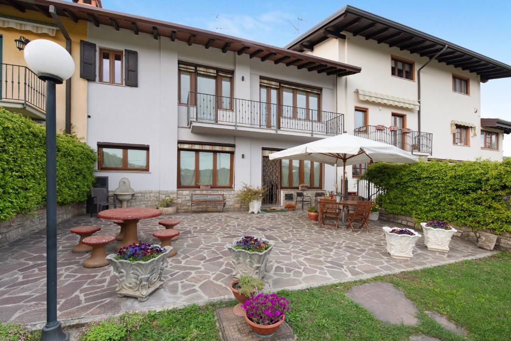 a patio in front of a house with an umbrella at Cascina Nonna Nina in Credaro