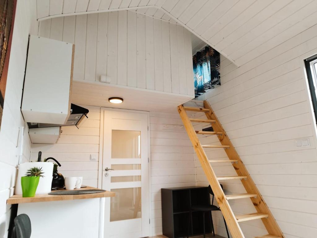 a tiny house with a staircase in a kitchen at Gospodarstwo Agroturystyczne Sunny Camp in Jerzmanowice