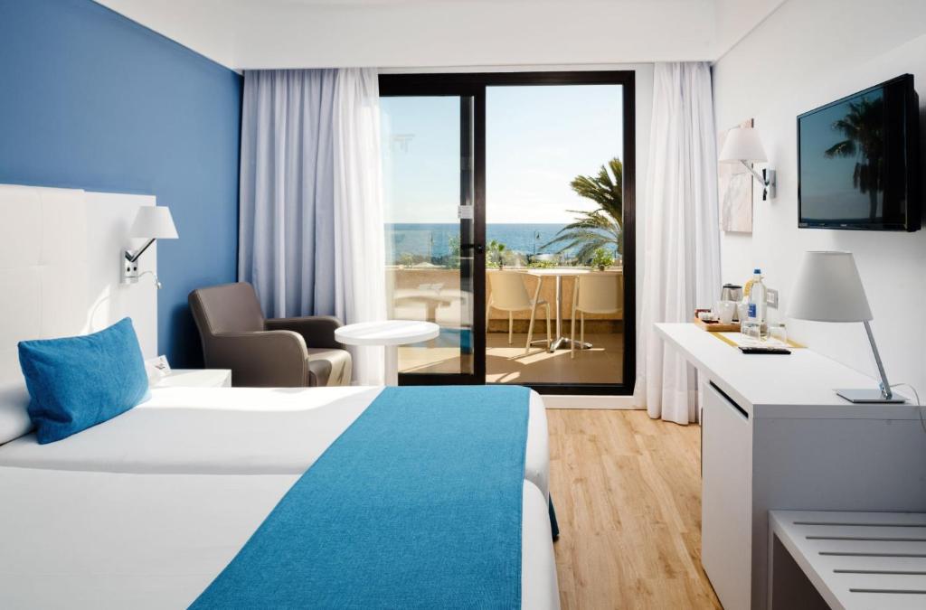 a hotel room with a bed and a view of the ocean at Alexandre Grand Teguise Playa in Costa Teguise