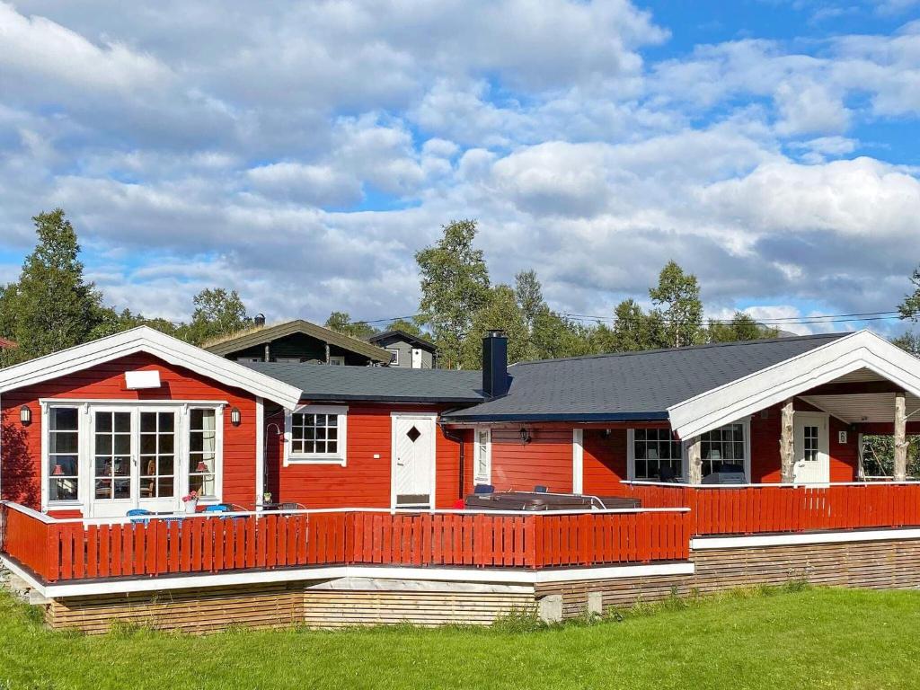 una casa roja con una valla roja delante de ella en Holiday home Gratangen II, en Gratangen